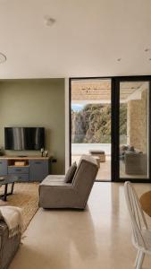a living room with a couch and a tv at The Cliff Residences in Plomari