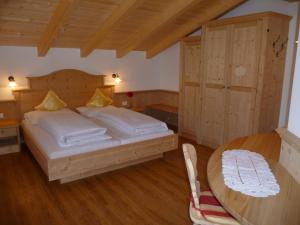 a bedroom with a large bed and a wooden table at Ferienwohnungen Obermoarhof in Lagundo