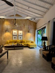 a living room with yellow couches and tables at Palace Bope Galle in Galle +2 photos