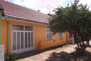 a small yellow house with a tree in front of it at Guest House Relax in Březí
