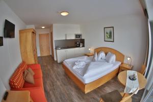 ein Schlafzimmer mit einem Bett, einem Tisch und einem Sofa in der Unterkunft Pension Apartment Hödner in Ebbs