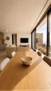 a wooden table in a living room with a large window at The Cliff Residences in Plomari