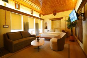 a living room with a couch and a bed and a tv at Gülten Hanım Konağı in Gaziantep
