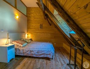 a bedroom with a bed and a staircase in a attic at La grange de martine in Saccourvielle +29 photos