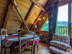 a room with a table and a chair and a window at La grange de martine in Saccourvielle