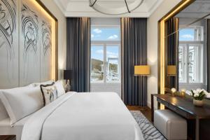 a bedroom with a large white bed and a desk at Matild Palace, a Luxury Collection Hotel in Budapest +186 photos
