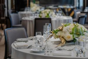 a table with white flowers and wine glasses on it at Matild Palace, a Luxury Collection Hotel in Budapest
