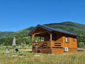 a cabin in a field with mountains in the background at Kućica na jezeru in Jezero