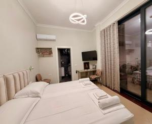 a bedroom with a large white bed and a window at Berat GuestHouse "AAA" in Berat