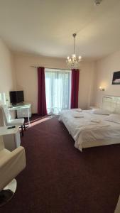 a bedroom with two beds and a desk and a chandelier at Hotel Imperial Timisoara by JR in Timişoara +27 photos