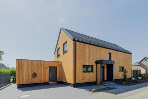 a wooden house with a black roof at Ferienhaus HeimatLay in Mörsdorf