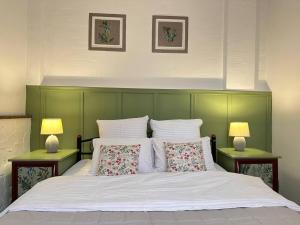 a bedroom with a green headboard and a bed with two lamps at Гостьовий дім PATRICK in Sanzhiyka +52 photos