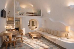 a living room with a couch and a table at Ikastikies Suites in Firostefani