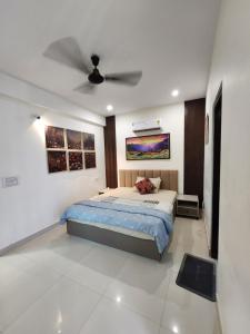 a bedroom with a bed and a ceiling fan at Shivara Homes in Jaipur