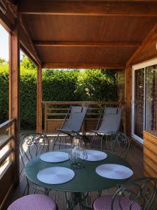 a patio with a table and chairs on a deck at Le petit chalet des Vosges proche Gerardmer in Corcieux