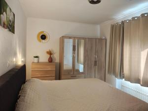 a bedroom with a bed and a wooden cabinet at The nest in Malmedy