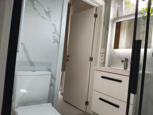 a bathroom with a white toilet and a sink at The nest in Malmedy
