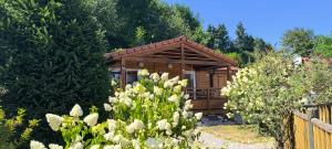 a small wooden cabin with a fence and flowers at Le petit chalet des Vosges proche Gerardmer in Corcieux