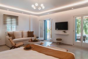 ein Wohnzimmer mit Sofa und Fernseher in der Unterkunft Alkyoni Beach Hotel in Naxos Chora + 110 Fotos