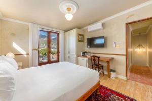 a bedroom with a bed and a desk and a television at Royva Bo-Kaap in Cape Town
