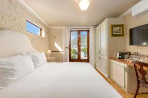 a bedroom with a large white bed and a window at Royva Bo-Kaap in Cape Town