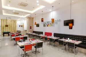 a restaurant with tables and chairs in a room at Red Fox by Lemon Tree Hotels, Sector 60, Gurugram in Gurgaon