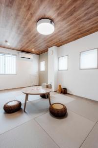 a living room with a table and two chairs at 余韻 -YOIN- Kofu 甲府中心街で夜を楽しむ貸切宿 in Kofu +64 photos