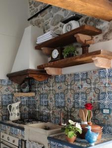 a kitchen with a sink and shelves on the wall at La casetta in Trabia +19 photos