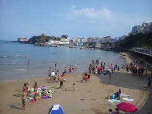 a large group of people on a beach at Osnok in Tenby +13 photos