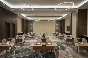 a conference room with tables and chairs and a screen at DoubleTree by Hilton Madinah Gate in Medina