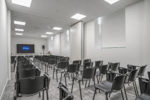 an empty room with chairs and a screen in it at Hampton By Hilton Locarno in Losone