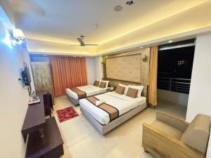 a hotel room with two beds and a couch at The White Beach Resort in Cox's Bazar