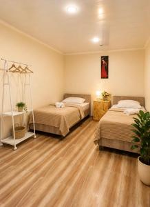 two beds in a room with wooden floors at PIT STOP B&B Guesthouse in Urtsʼadzor +12 photos