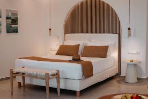 ein Schlafzimmer mit einem großen weißen Bett und einem Tisch in der Unterkunft Alkyoni Beach Hotel in Naxos Chora