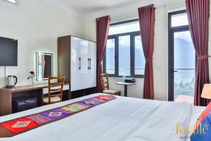 a bedroom with a bed and a desk and window at JOVILLE HOTEL SAPA in Sapa +51 photos