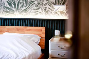 a bedroom with a bed with a wooden headboard and a night stand at Côté cour, côté source chambre d'hôtes in Chaudfontaine