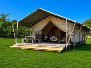 a large tent with a deck in the grass at Canvas chill-out in Ladignac-le-Long
