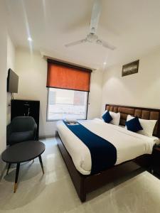 a bedroom with a bed and a chair and a window at Hotel Ivory Delhi Airport in New Delhi +14 photos