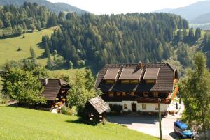 a house with solar panels on the side of a hill at Ferienwohnung Lahnerhof in Arriach