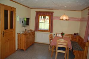 a dining room with a table and chairs and a television at Ferienwohnung Lahnerhof in Arriach