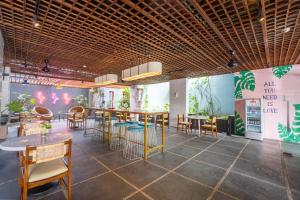 a restaurant with wooden ceilings and tables and chairs at Liberta Seminyak Hotel in Seminyak