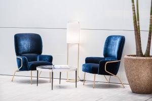 two blue chairs and a table in a room at INNSiDE by Meliá Milano Torre GalFa in Milan
