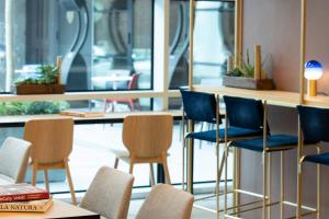 a room with chairs and a table with a mirror at INNSiDE by Meliá Milano Torre GalFa in Milan +74 photos