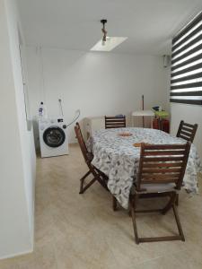 a dining room with a table and chairs and a washing machine at VIVIENDA TURÍSTICA Bajo, 7 Escaleras in Laxe