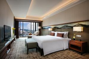 a bedroom with a large white bed and a large window at Intercontinental Jinan City Center by IHG in Jinan
