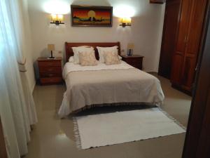 een slaapkamer met een bed met 2 nachtkastjes en 2 tafels bij Vivienda Vacacional Paseo Mirabal in Icod de los Vinos