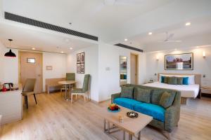 a hotel room with a bed and a living room at Red Fox by Lemon Tree Hotels, Sector 60, Gurugram in Gurgaon