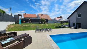 a backyard with a swimming pool and a house at Vila pod Majákem in Přítluky