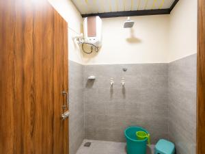 a bathroom with a wooden door and a green bucket at Hotel Diamond inn Mathura in Mathura