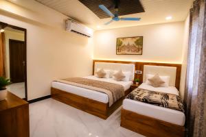 a hotel room with two beds and a window at Hotel Diamond inn Mathura in Mathura